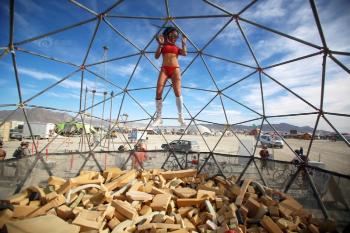 Lulu, her Playa name, falls into a foam pit as approximately 70,000 people from all over the world gather for the 30th annual Burning Man arts and music festival in the Black Rock Desert of Nevada, U.S.